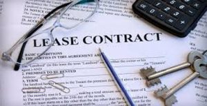Image of a lease contract with glasses, paper clips, keys and a calculator on top of it, retail store lease consideration when you are closing your store